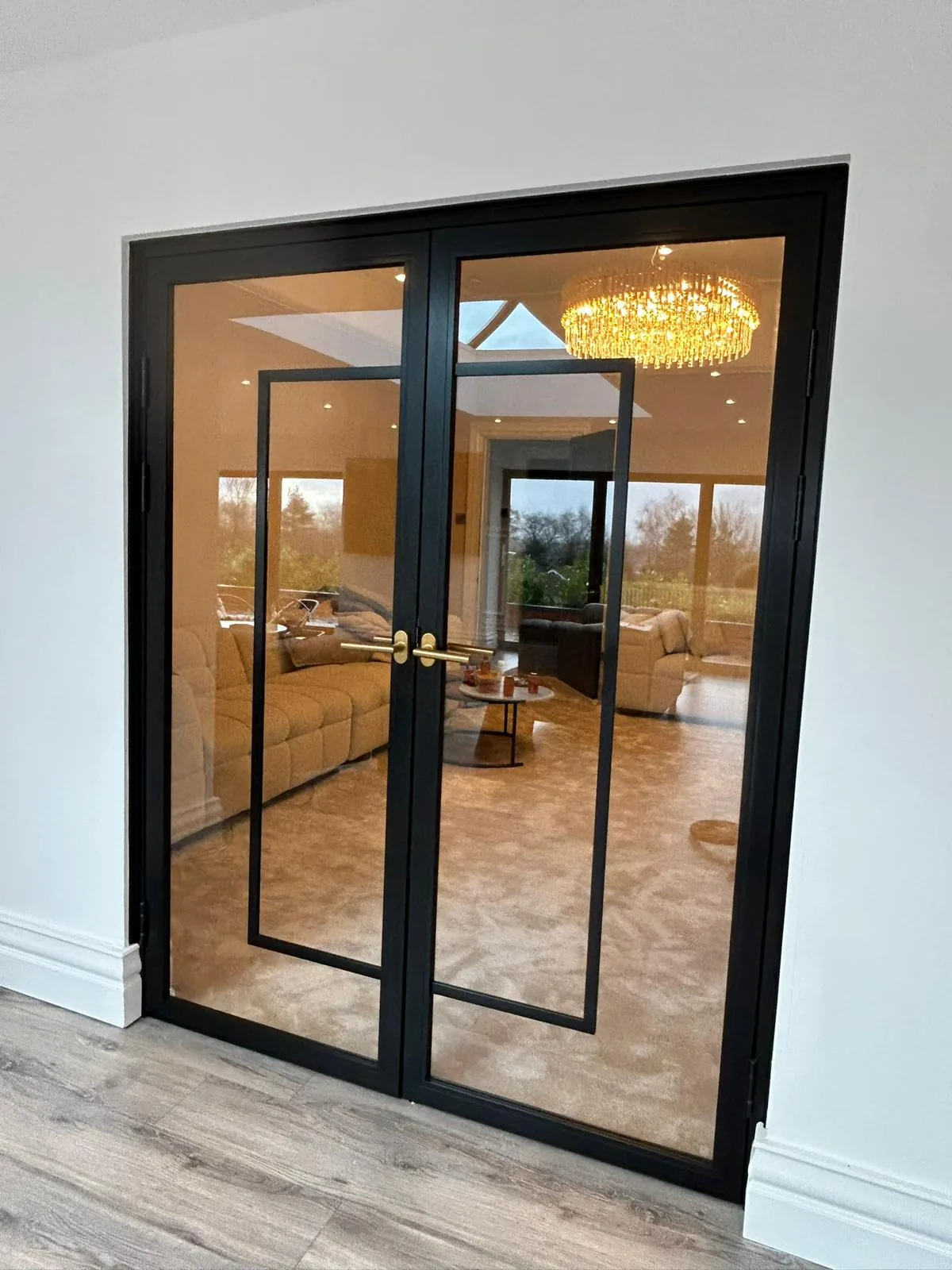 Black slim-frame Crittall-style internal doors with full-height glazing in a Lancashire home